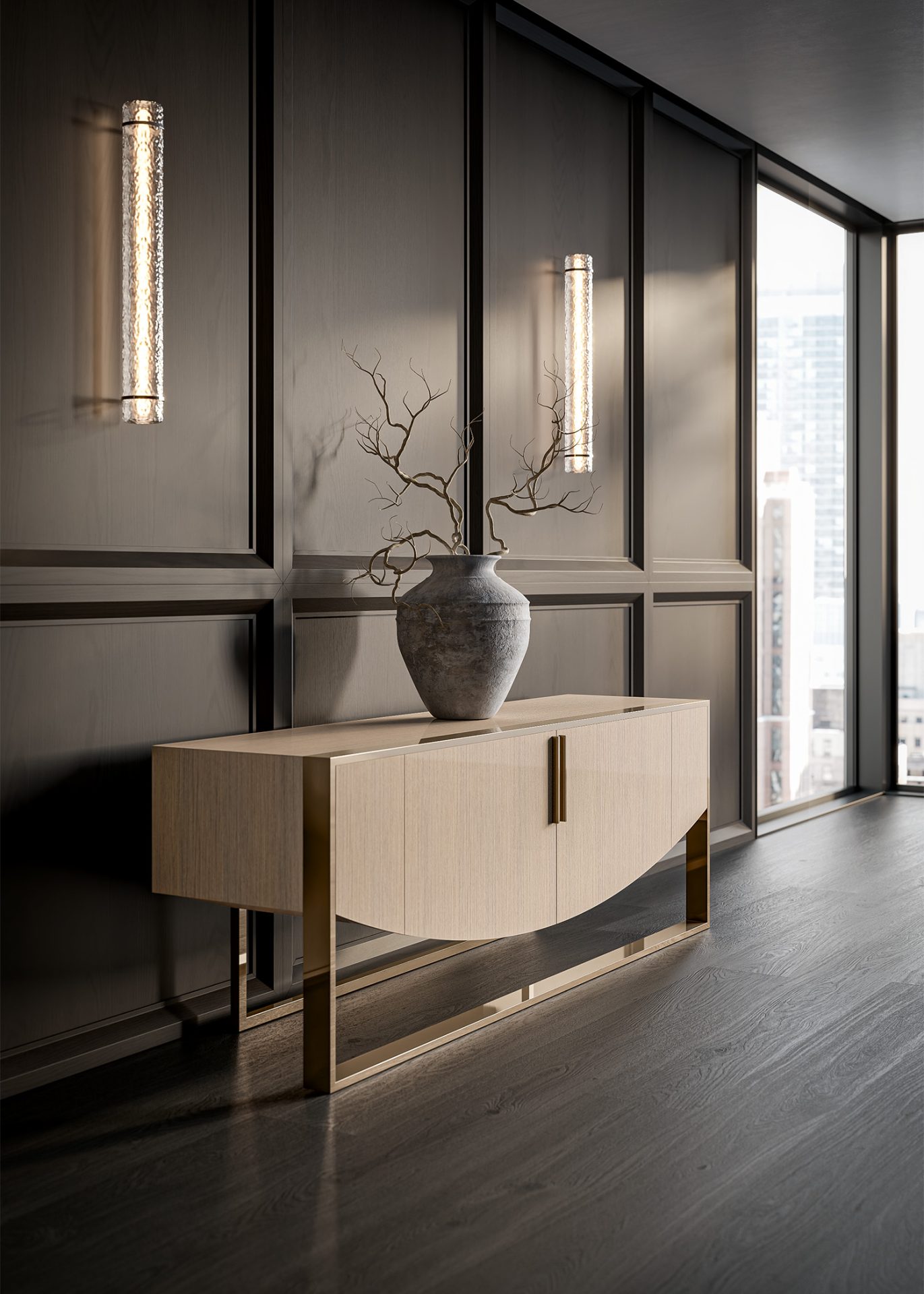 The Moon Sideboard stands on gold legs, topped with a ceramic vase of bare branches, placed before dark paneled walls with sconces and a window framing the city skyline.