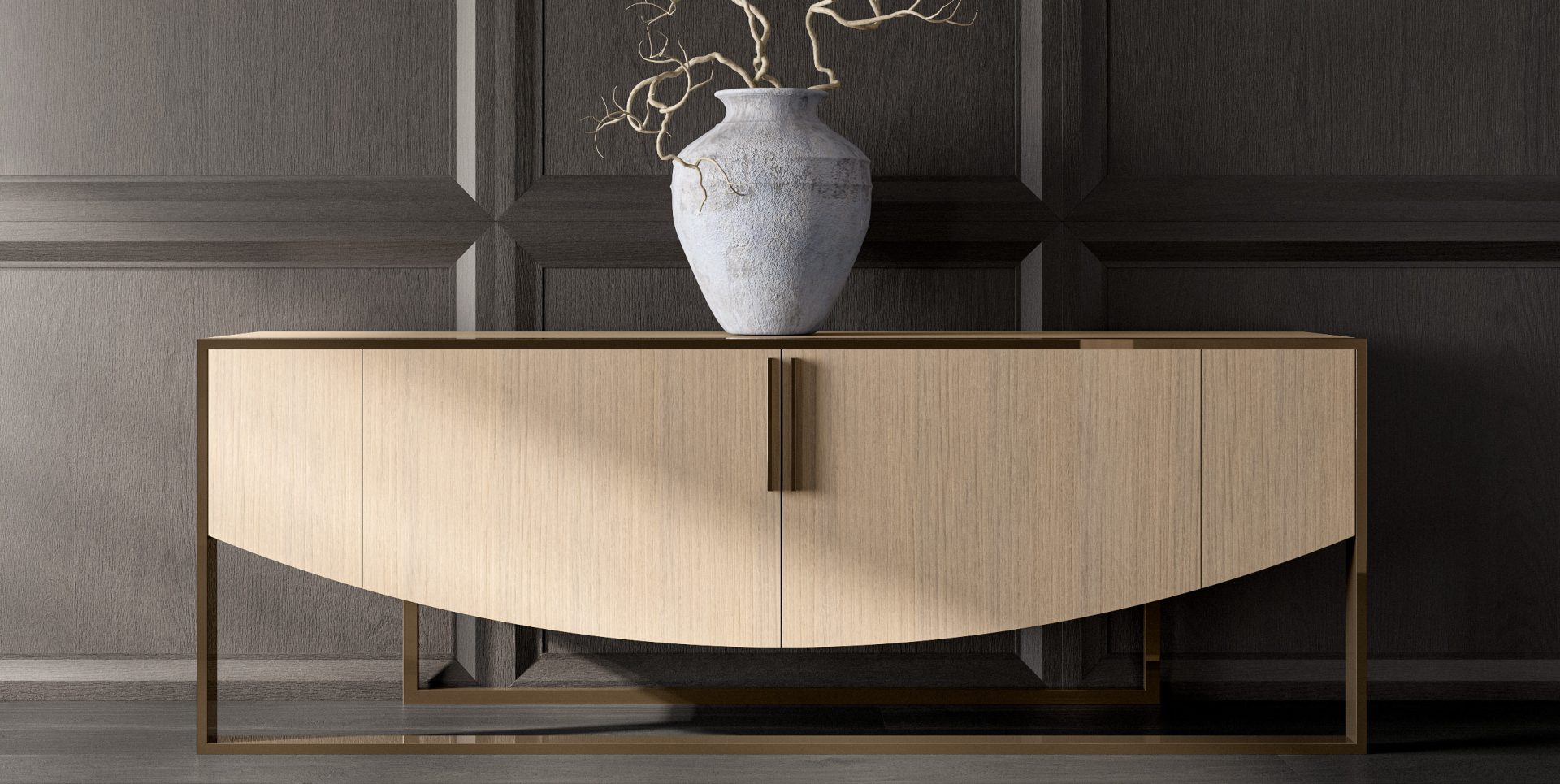 A modern Moon Sideboard features a light wood finish with a curved front, set against a dark paneled wall, and is topped with a large ceramic vase displaying bare branches.