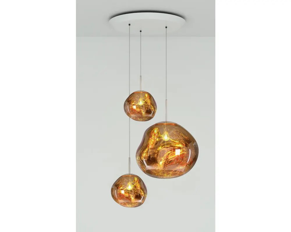 The Melt Trio Round Pendant System features three irregularly shaped amber glass pendants hanging from a white ceiling mount against a plain light-colored background.