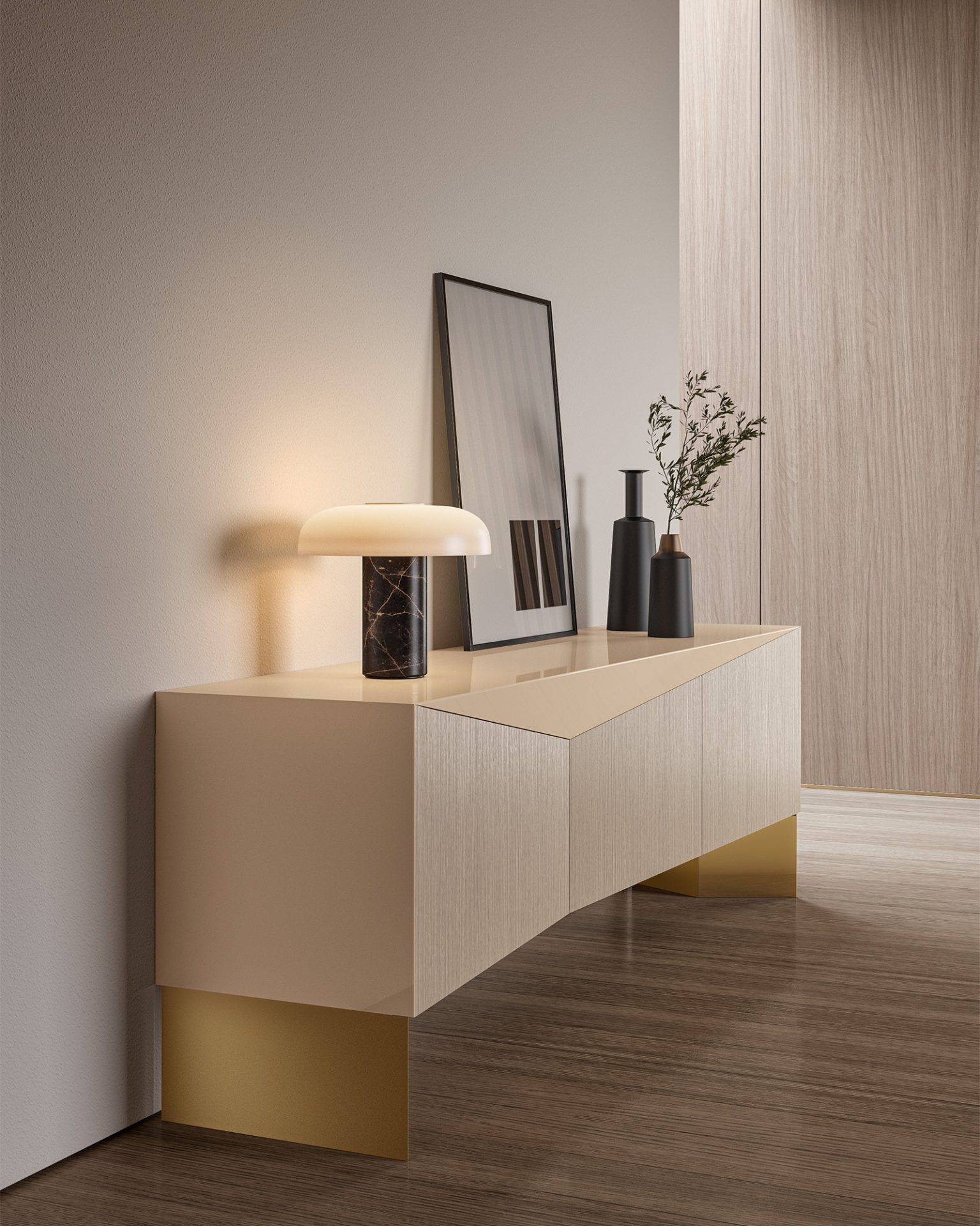 The Moon Console (Copy) in beige and gold is styled with a lamp, framed mirror, two vases, and a branch against a neutral wall and wood floor.