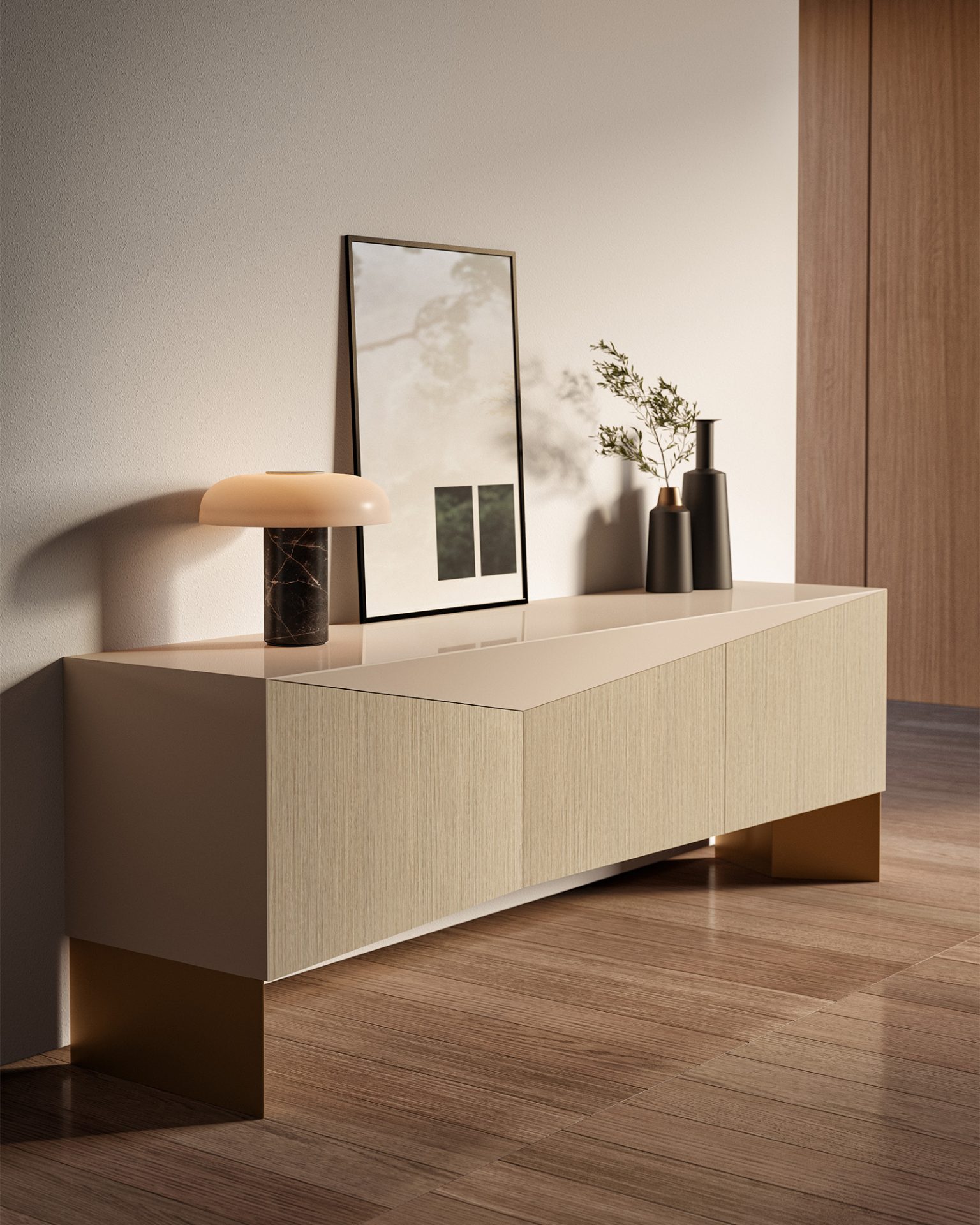 The Moon Console (Copy) with metallic legs, a table lamp, minimalist vases with greenery, and framed artwork stands against a neutral wall on a wooden floor.